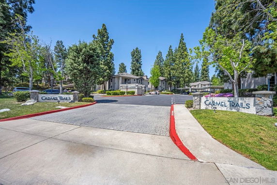Front view of a residential complex with signs reading 'Carmel Trails'.