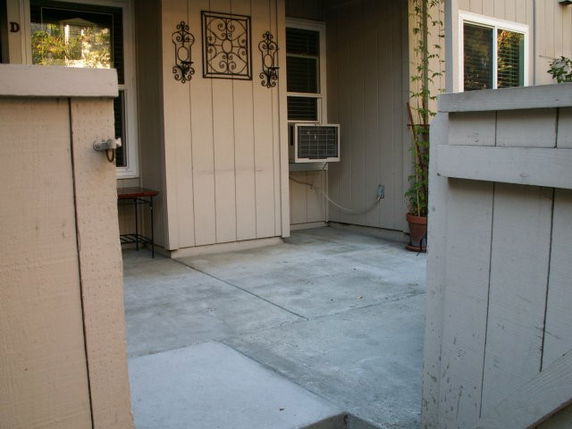 Front view of a house entrance with an air conditioning unit and decorative wall art.