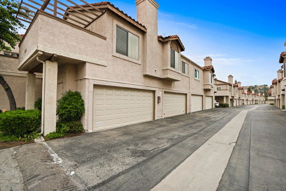 Front view of a multi-story row of townhouses with garages.