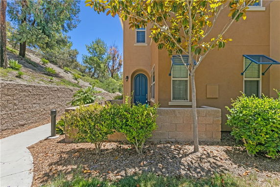 Front view of a house with a blue arched door and three windows.