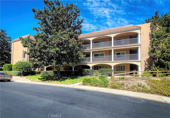 Front view of a three-story apartment building with balconies.