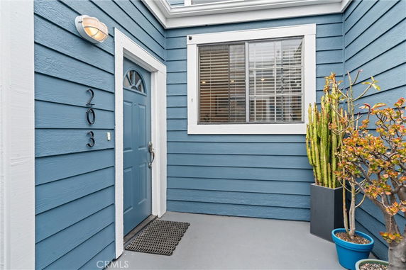 Front view of a house entry with blue siding and plants.