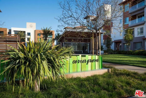 Exterior view of a multi-story residential building with modern design elements and landscaping.