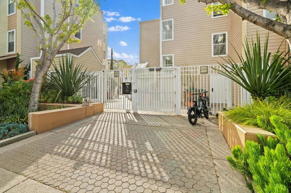 Front view of a residential building with gated entrance and cycling facilities.