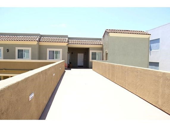 Front view of a building with a flat roof and tile accents.