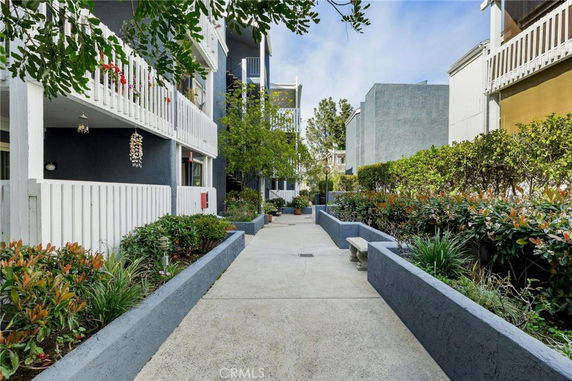 Front view of a multi-story building with balconies and landscaping.