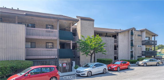 Front view of a multi-story apartment building with balconies.