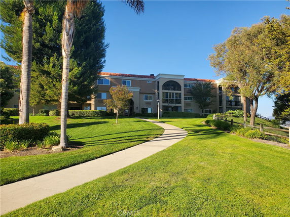 Front view of a multi-story building with a pathway leading to the entrance.