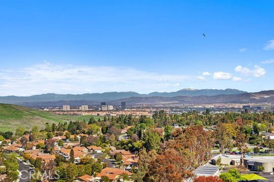 Panoramic view of a suburban area with a background of mountains and clear blue sky.