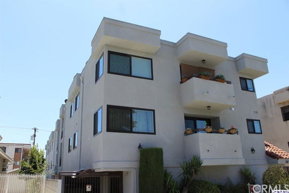 Front view of a multi-story apartment building with balconies.