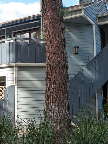 Front view of a two-story house with blue siding and a balcony.