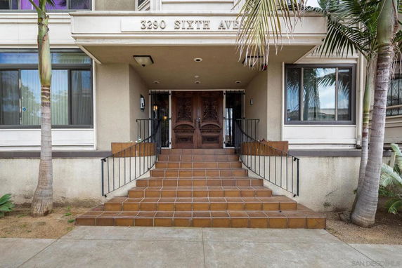 Front view of a building entrance with steps leading up to double doors.