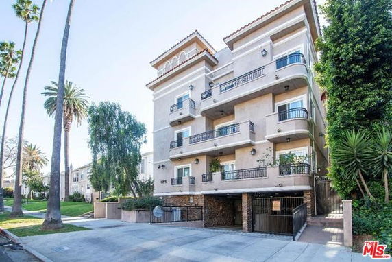 Front view of a multi-story residential building with balconies.