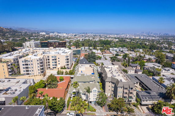 Aerial view of residential buildings in an urban area with surrounding greenery.