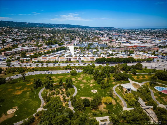 Panoramic aerial view of a suburban area with residential buildings and greenery.