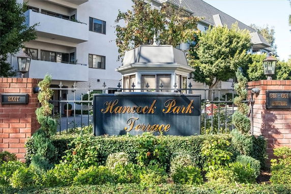 Front view of a multi-story residential building with a gated entrance.