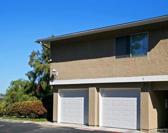 Front view of a building with two garages and a window on the upper floor.