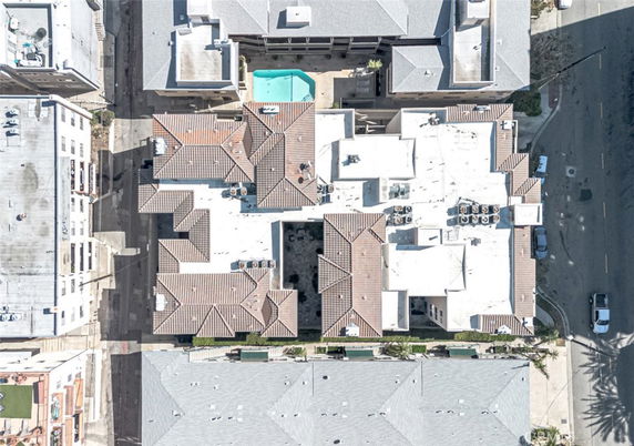 Aerial view of a building rooftop with multiple structures and air conditioning units.