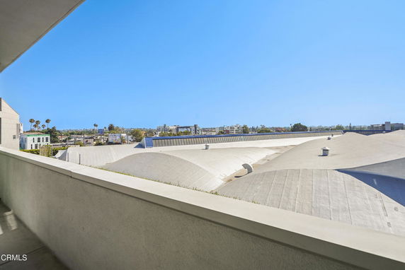 View from the building's rooftop with curved structures and vents.