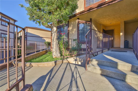 Front view of a residential building with stairs leading to the entrance.