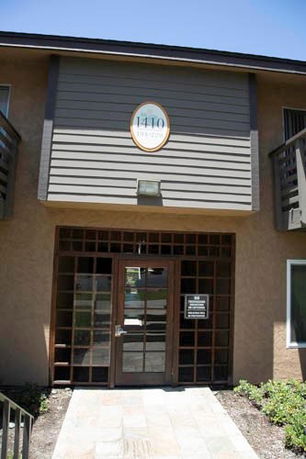 Front view of a building entrance with a double-door and wooden paneling.