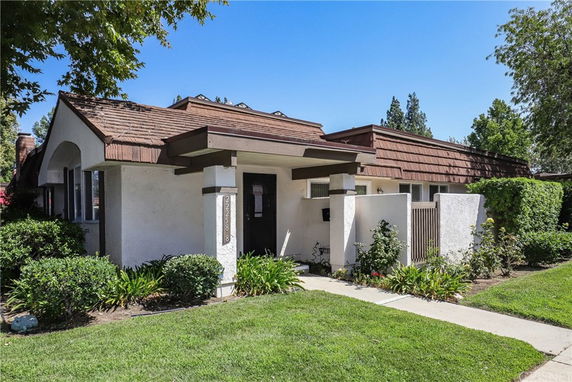 Front view of a single-story house with brown roof and white exterior walls.
