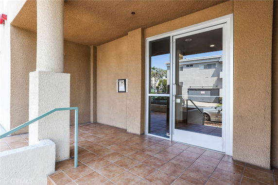 Entrance view of a building with tiled flooring and glass door.