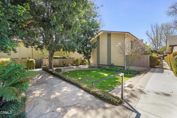 Front view of a single-story house with a walkway and garden.