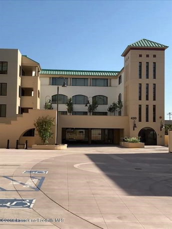 Front view of a multi-story building with a tower and green roof.