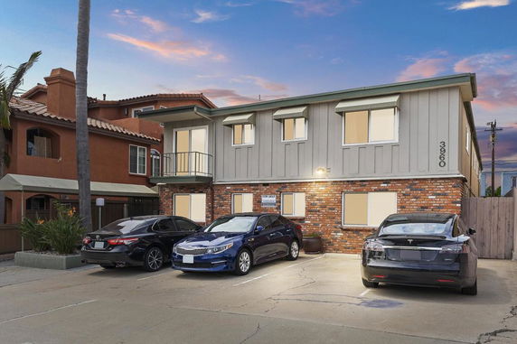 Front view of a two-story building with parking area.