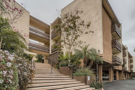 Front view of a multi-story building with external staircases and balconies.