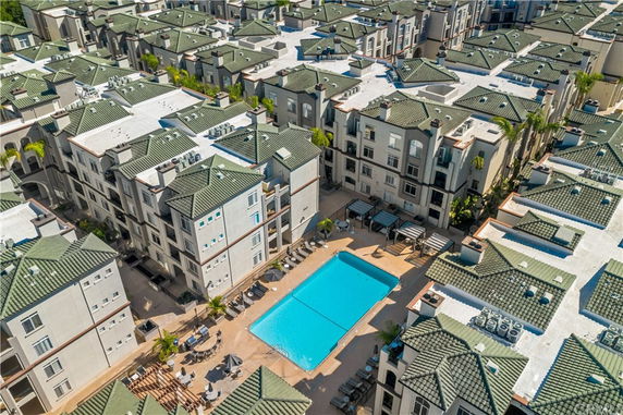 Aerial view of a residential complex with a central outdoor pool area surrounded by multi-story buildings.