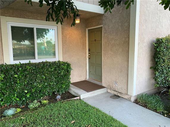 Front view of a house entrance with a green door and window.