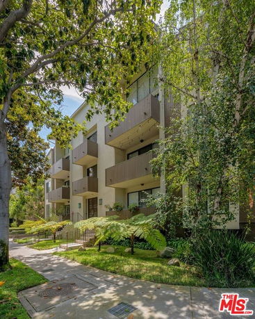 Front view of a multi-story apartment building with balconies.