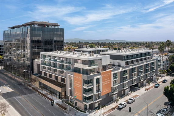 Front view of a modern multi-story commercial building with glass features.