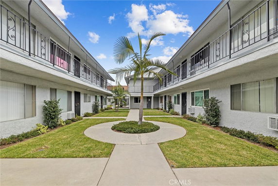 Front view of a two-story apartment building with exterior corridors and a central courtyard.