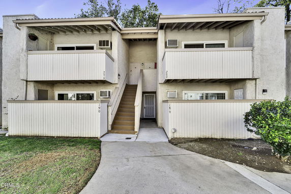 Front view of a multi-story building with exterior staircases and balcony features.