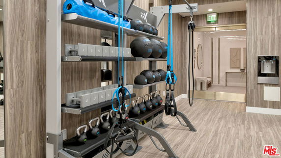 Indoor gym area with exercise equipment and storage racks.