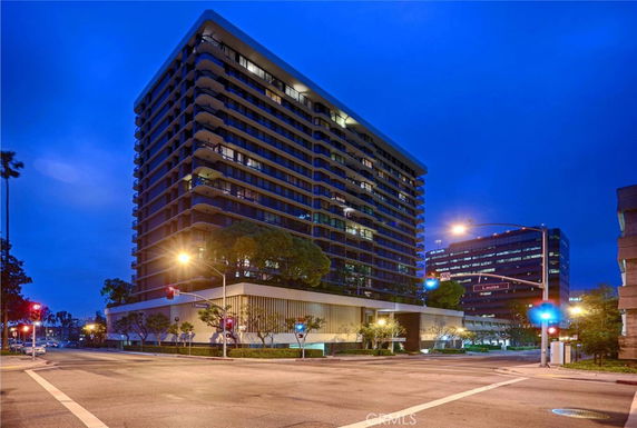Front view of a high-rise building with several floors and balconies.