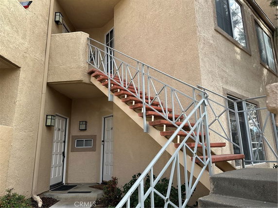 Front view of a multi-story building with exterior stairs.