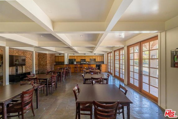 Indoor recreational area with tables, chairs, and a kitchen.