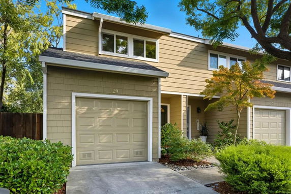 Front view of a two-story house with a garage and an entrance.