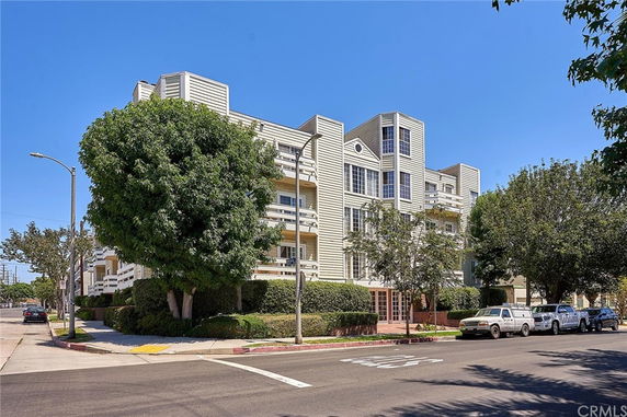 Front view of a multi-story apartment building with balconies and a modern design.
