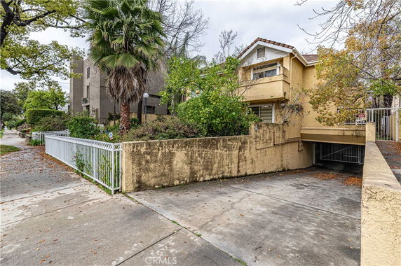 Front view of a two-story house with a driveway and a gated entrance.
