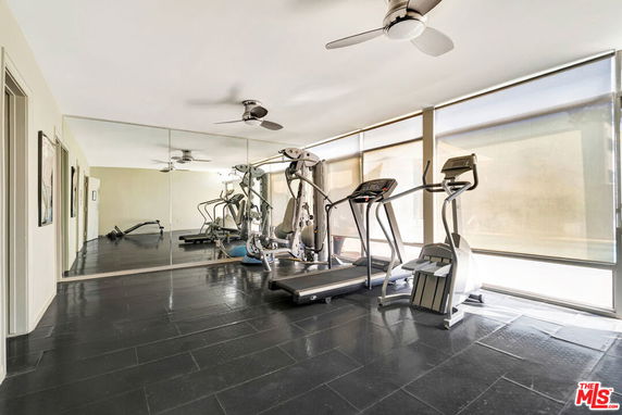 Indoor gym area with exercise equipment and mirrored wall.