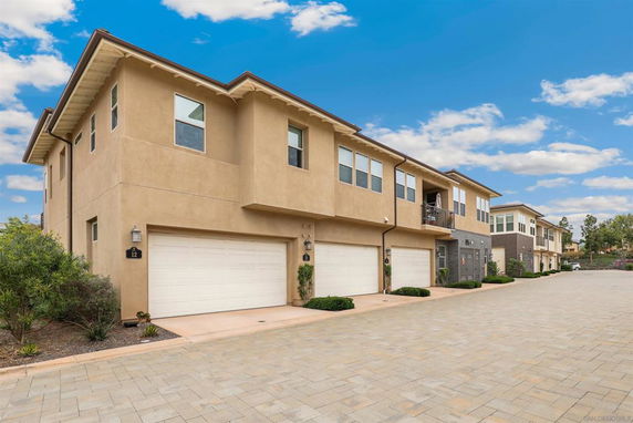 Front view of a row of two-story townhouses with garages.