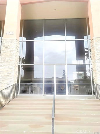Front view of a building with large glass windows and stone accents.