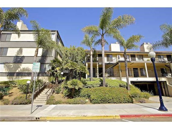 Front view of a multi-story residential building with balconies and landscaping.