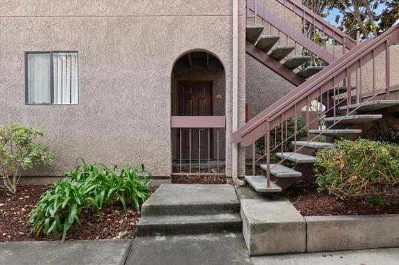 Front view of a building entrance with stairs leading up to the second level.