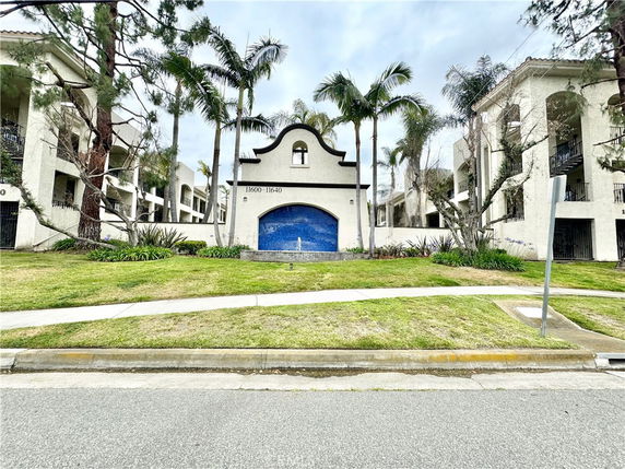 Front view of a multi-story apartment building with an archway entrance.